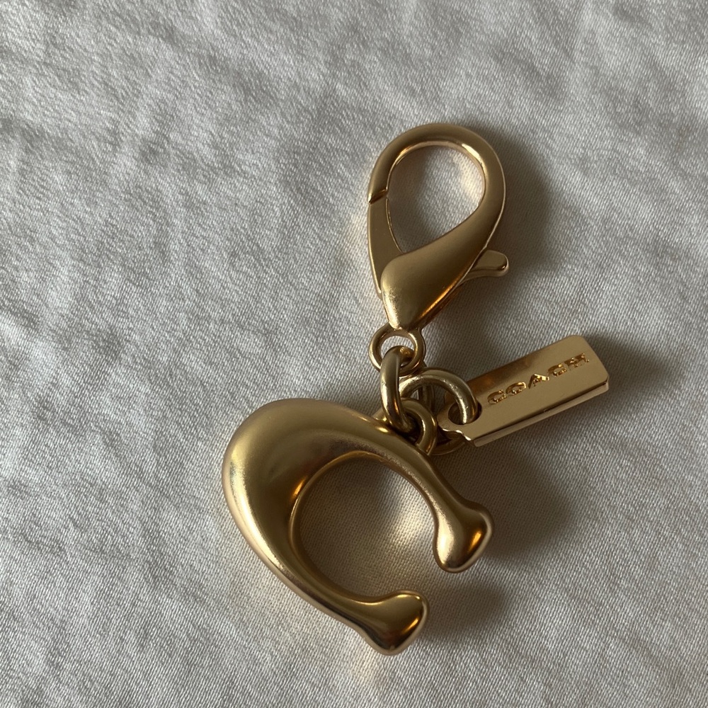 Coach: Metallic Gold Tone “C” Charm Accessory